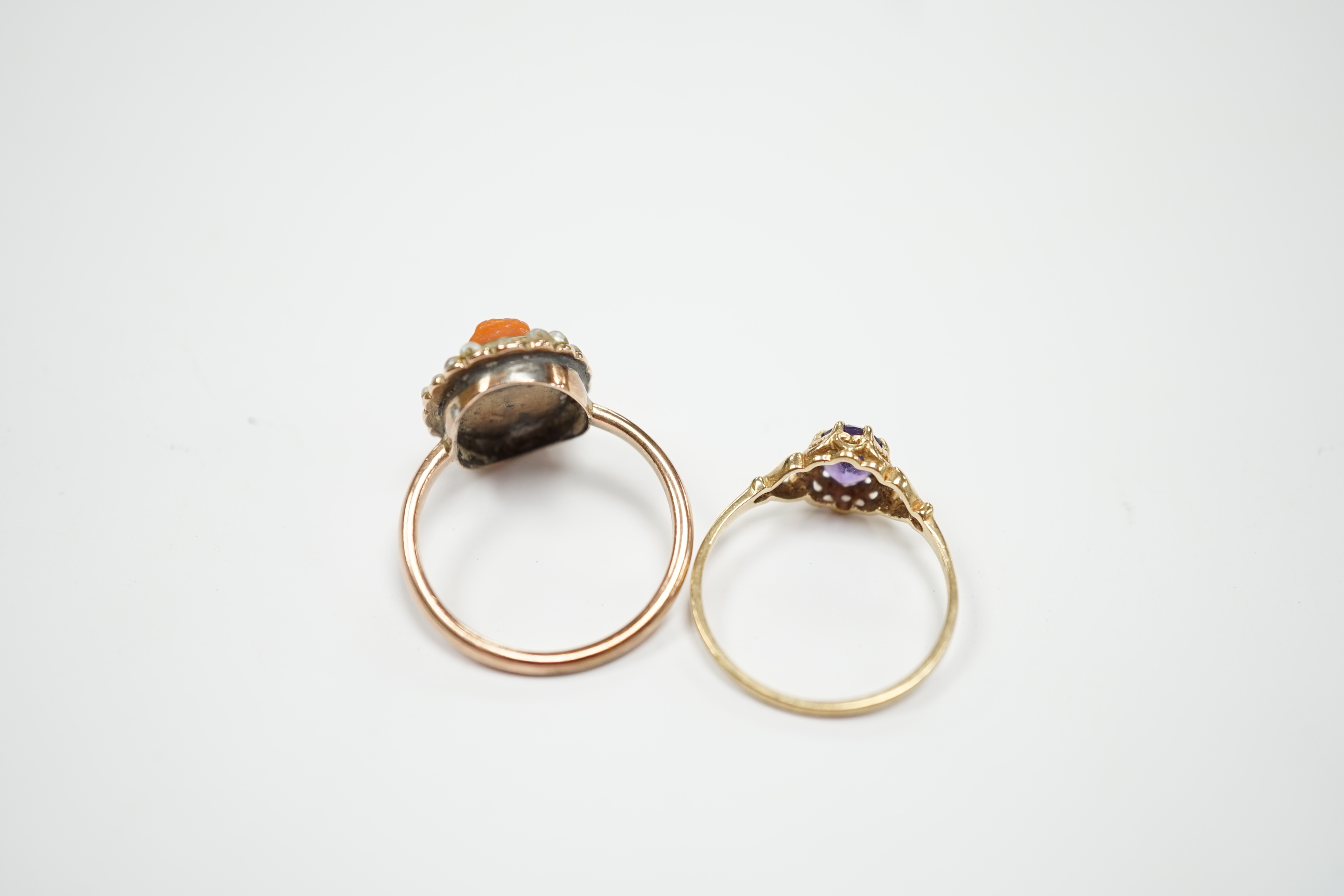 A modern 9ct gold and single stone amethyst set ring and a yellow metal, carved coral and split pearl set ring.